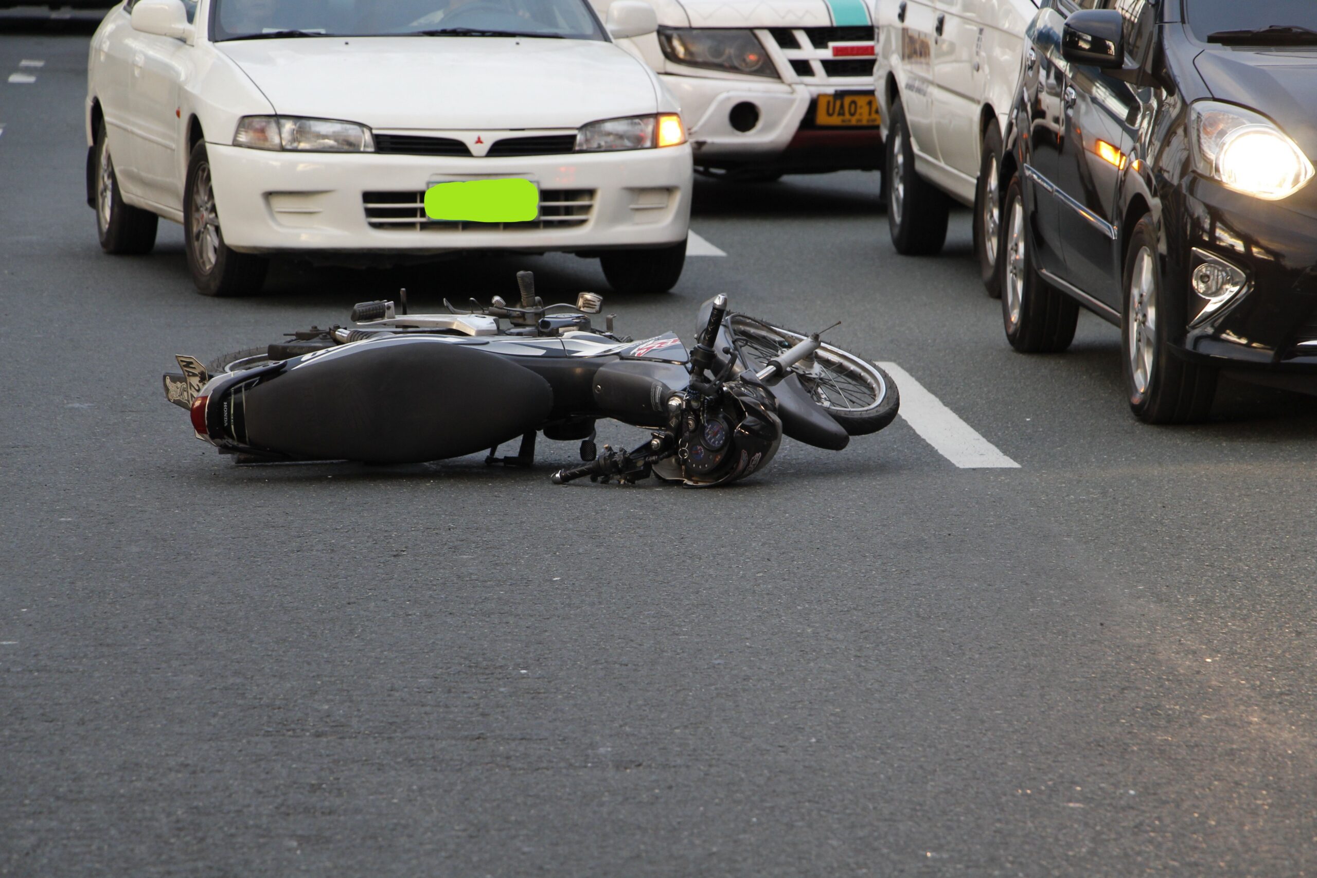 Motorcycle lying on a city road after a crash involving an uninsured or underinsured driver