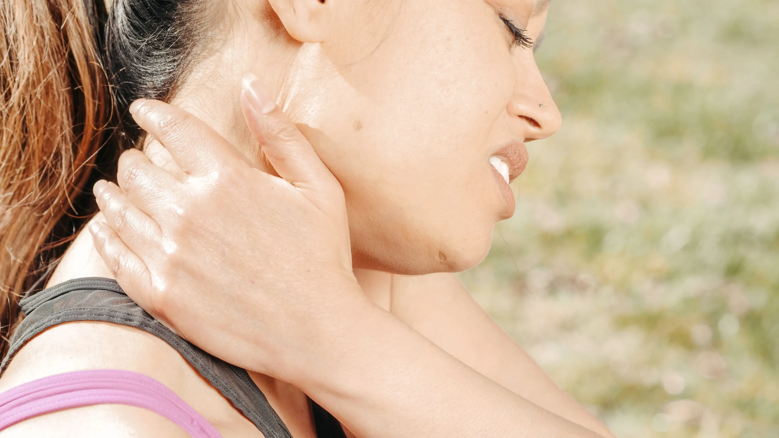 Woman holding her neck in pain after an accident, showing why early medical care strengthens an injury claim
