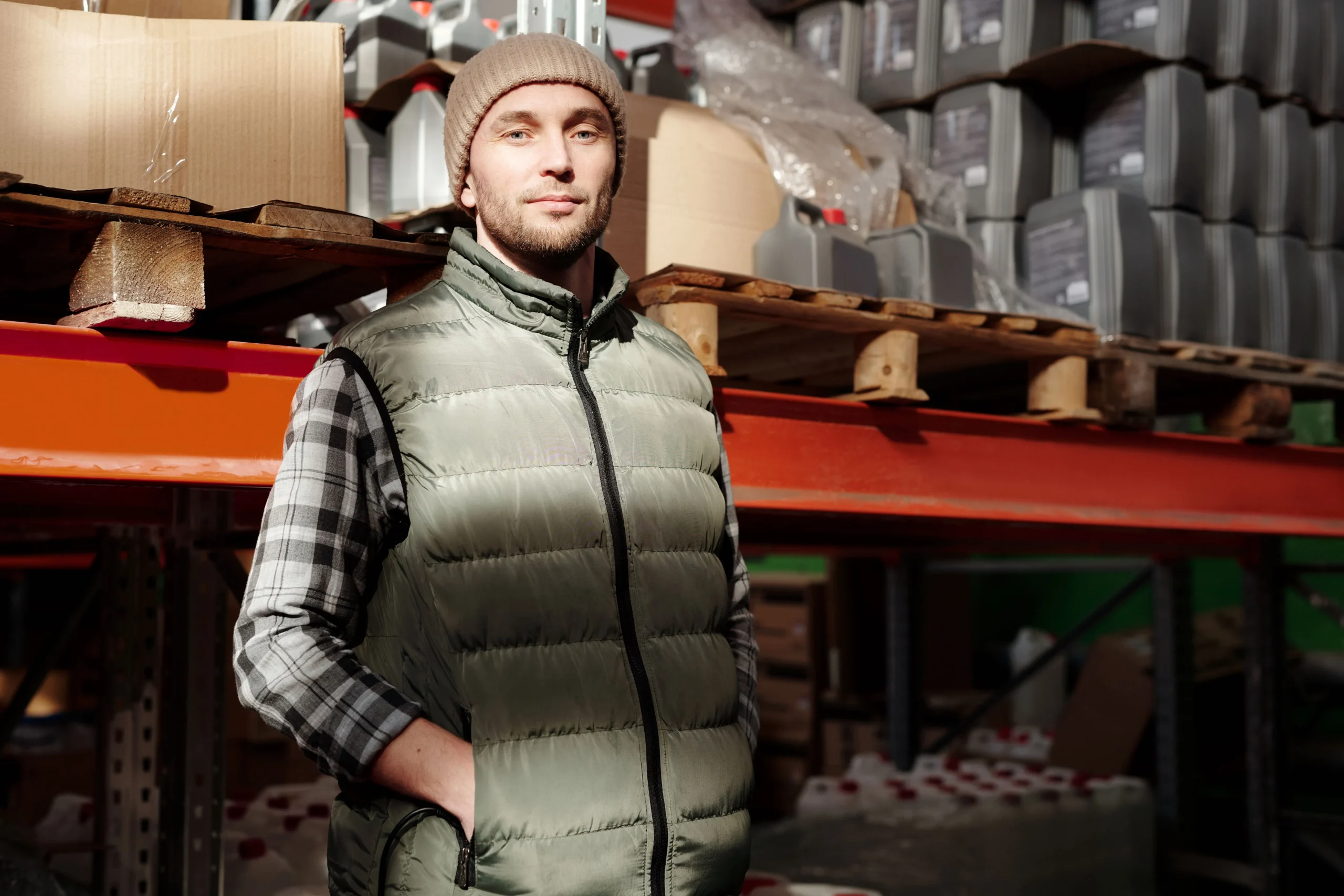 warehouse-worker-unpaid-overtime-california.webp Warehouse worker standing beside stocked shelves, an industry where unpaid overtime is common in California